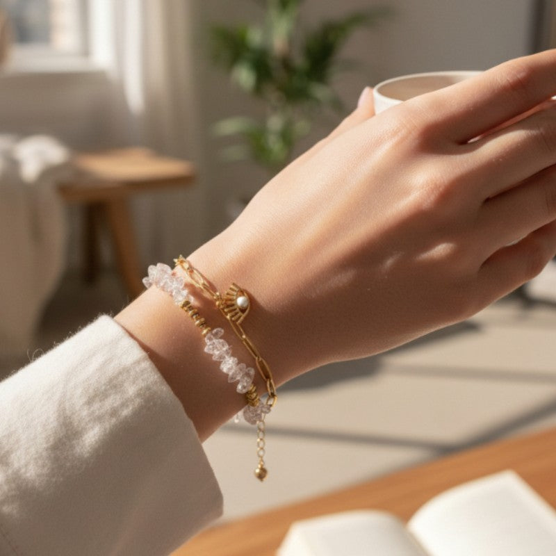 Bracelet mauvais œil en cristal de roche porté au poignet d'une femme, pierres transparentes et chaîne dorée OCULUS®