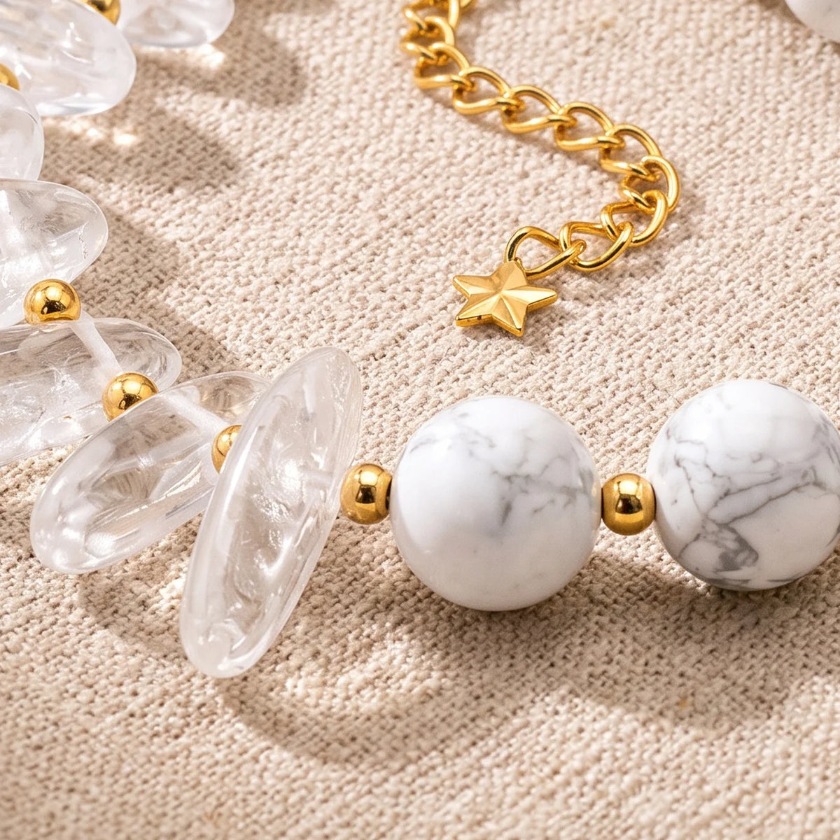 Gros plan sur les pierres du bracelet en cristal de roche DUALIA®, perles dorées et breloque étoile