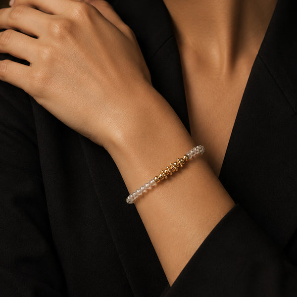 Bracelet pierre cristal de roche FINA® porté au poignet d'une femme, perles facettées et perles dorées