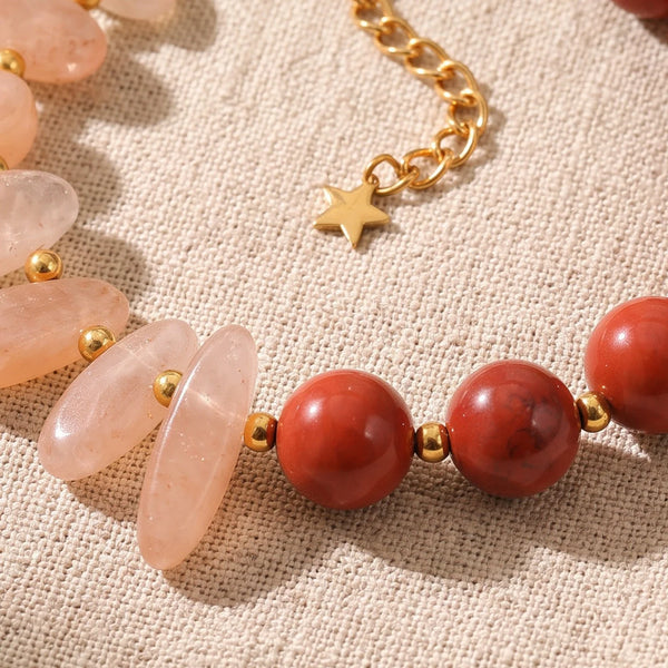 Gros plan sur les pierres du bracelet en pierre de lune rose DUALIA®, perles dorées et breloque étoile