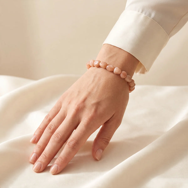 Bracelet orange femme en pierre de soleil roulée, porté au poignet