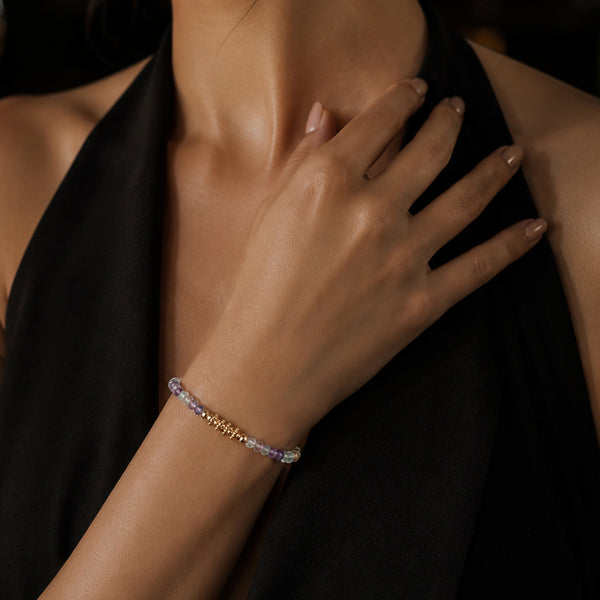 Bracelet pierre fluorite (fluorine) multicolore FINA® porté au poignet d'une femme, perles facettées et perles dorées