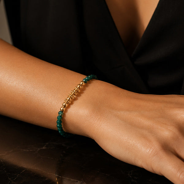 Bracelet pierre quartz fuchsite FINA® porté au poignet d'une femme, perles facettées et perles dorées