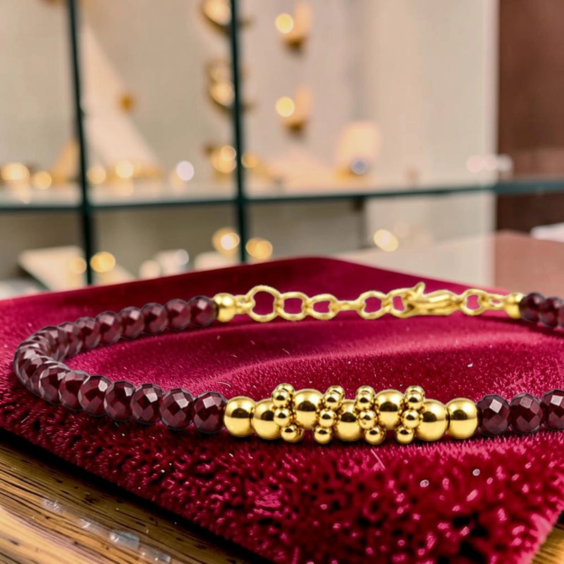 Détail des perles facettées en grenat rhodolite et du motif de perles en acier doré, bracelet FINA®