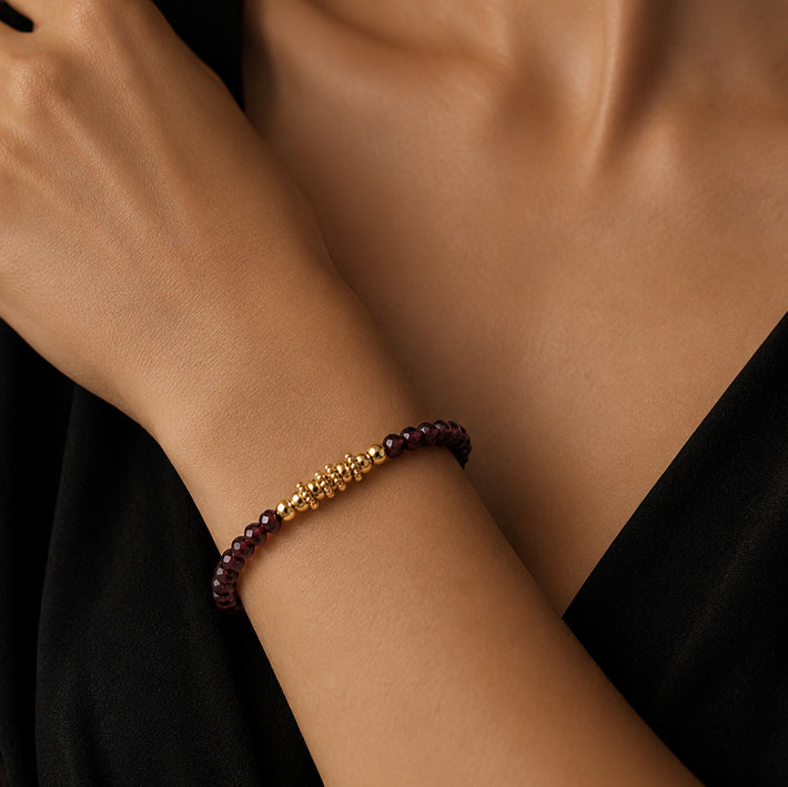 Bracelet pierre grenat rhodolite FINA® porté au poignet d'une femme, perles facettées et perles dorées