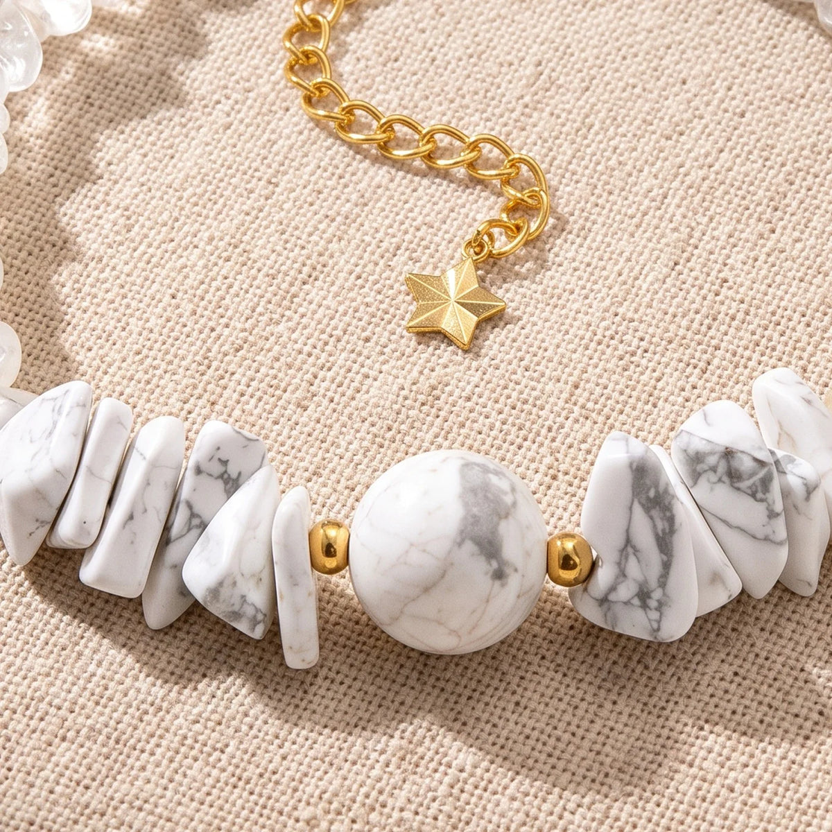 Gros plan sur les pierres du bracelet en howlite CÉLIA®, perles dorées et breloque étoile