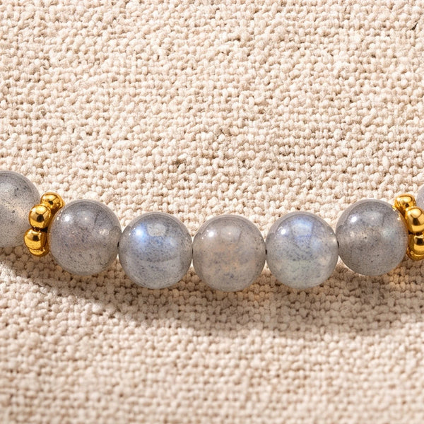 Gros plan sur les perles de labradorite de 4 mm et les rondelles fleurs dorées du bracelet ORÉLIA®