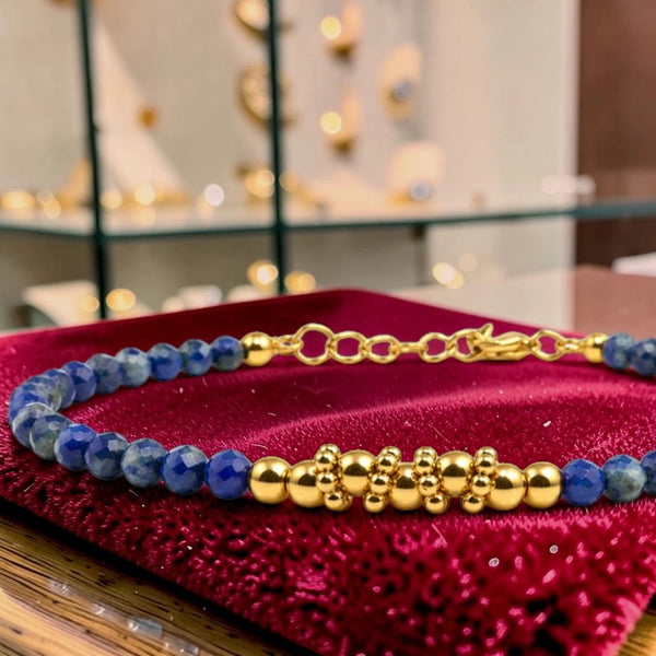 Détail des perles facettées en lapis-lazuli et du motif de perles en acier doré, bracelet FINA®