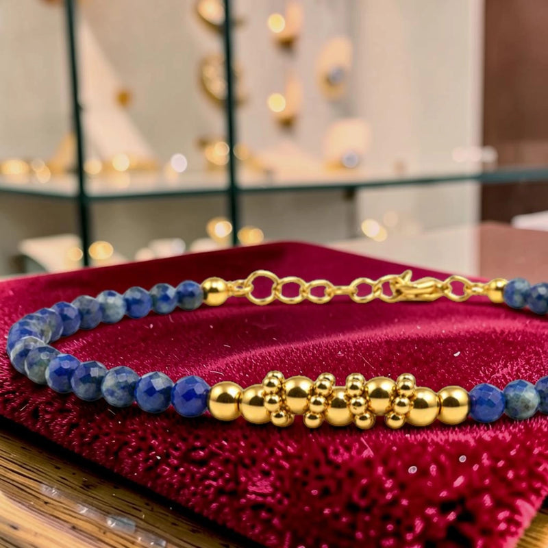 Détail des perles facettées en lapis-lazuli et du motif de perles en acier doré, bracelet FINA®