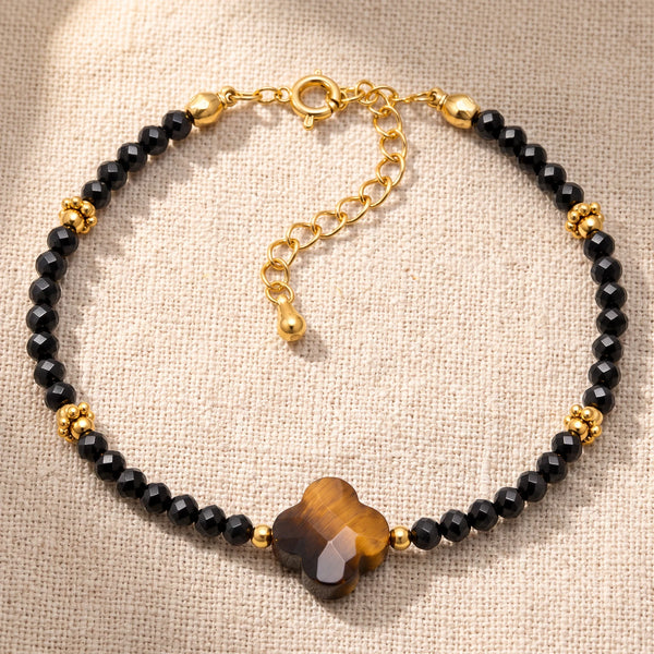 Bracelet pierre naturelle marron TRÉFLIA®, un trèfle d'œil de tigre et des perles d'onyx noir, chaîne dorée