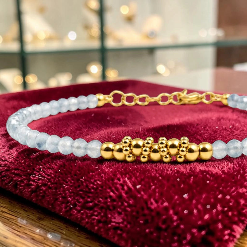 Détail des perles facettées en aigue-marine et du motif de perles en acier doré, bracelet FINA®