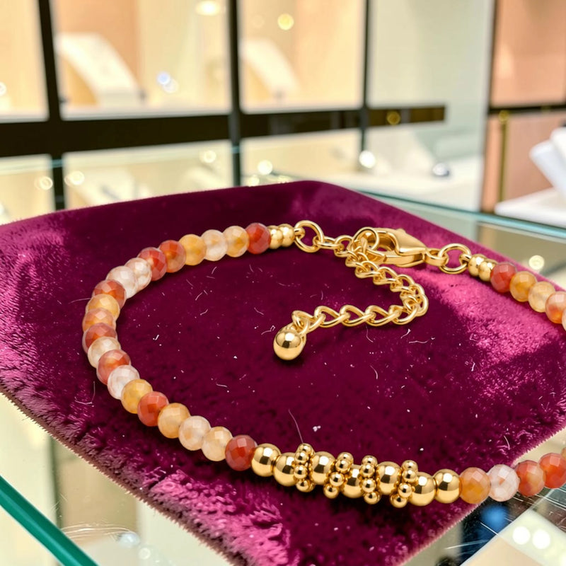 Détail des perles facettées en cornaline et du motif de perles en acier doré, bracelet FINA®