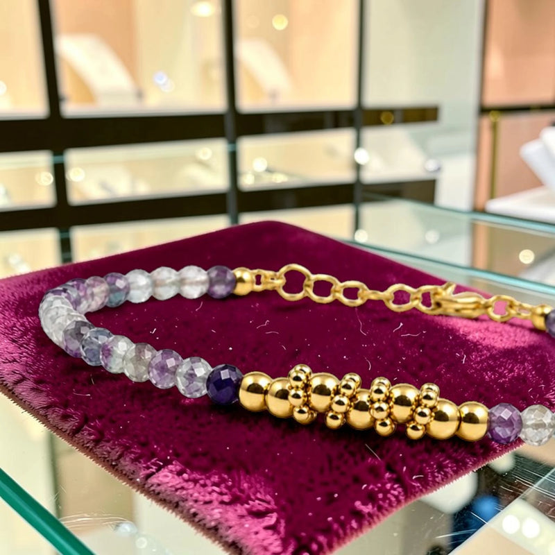 Détail des perles facettées en fluorite (fluorine) multicolore et du motif de perles en acier doré, bracelet FINA®