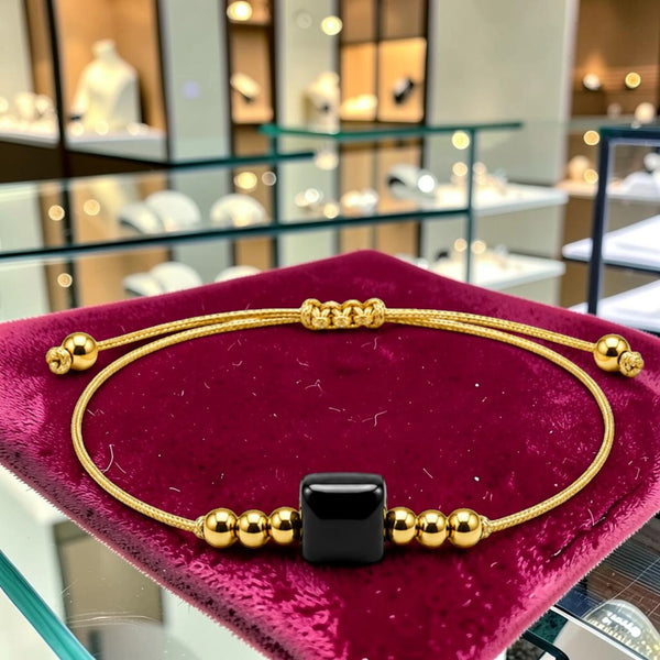 Bracelet pierre naturelle onyx noir femme CUBE®, pierre cube 8 mm entre perles acier doré sur cordon couleur or