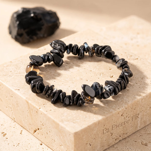 Bracelet onyx noir en pépites baroques posé sur travertin, pierre d'ancrage