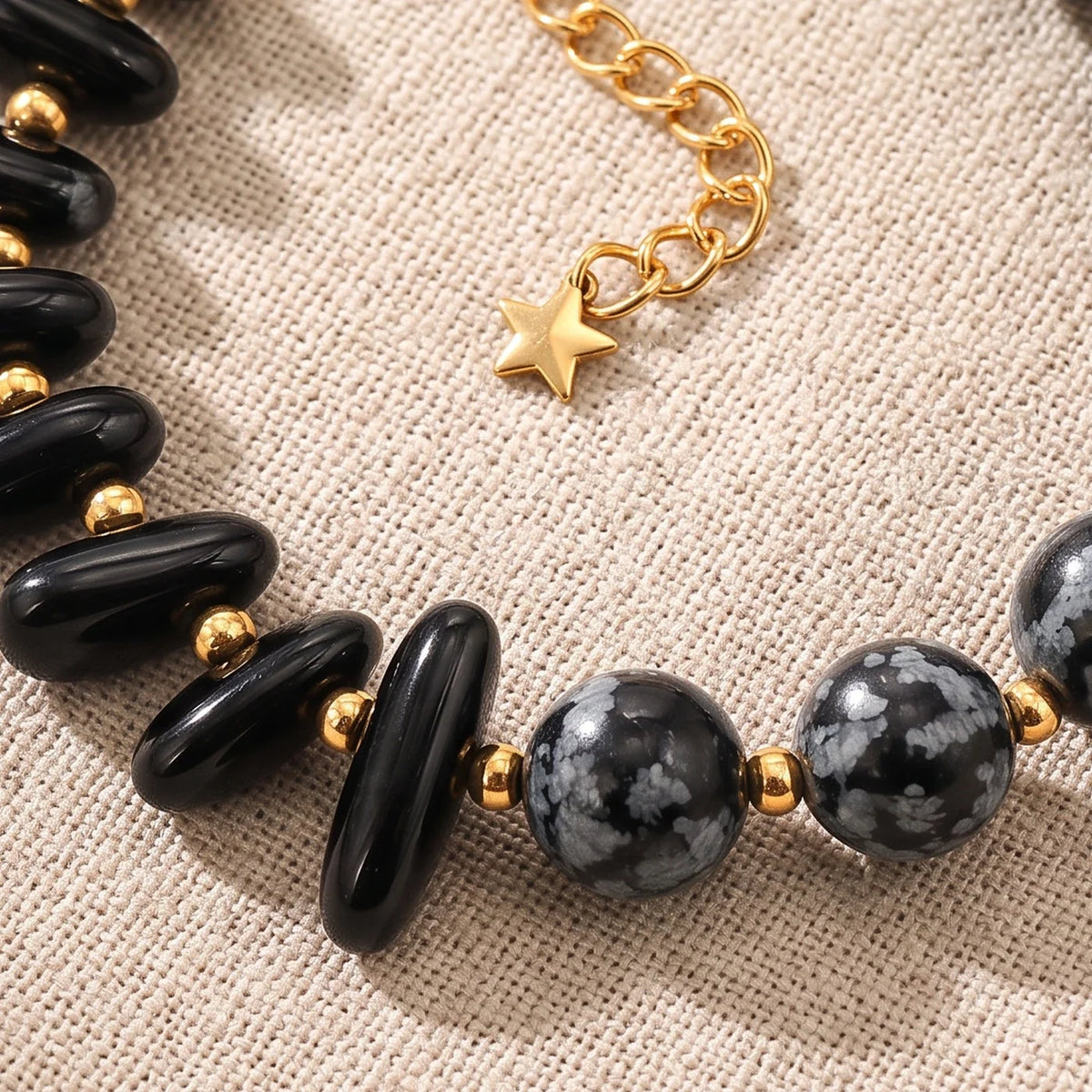 Gros plan sur les pierres du bracelet en obsidienne neige DUALIA®, perles dorées et breloque étoile