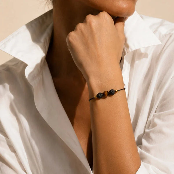 Bracelet œil de tigre et pierre de lave LAVIA® porté au poignet d'une femme