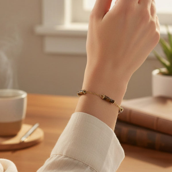 Bracelet heishi en œil de tigre porté au poignet d'une femme, perles miel doré et chaînette dorée QUATUOR®