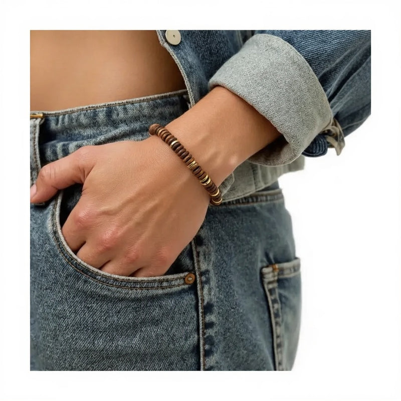 Bracelet pierre naturelle œil de tigre porté au poignet d'une femme, perles plates miel doré et acier doré DISQUE®