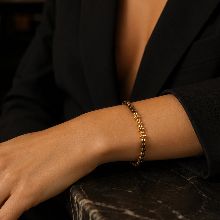 Bracelet pierre œil de tigre FINA® porté au poignet d'une femme, perles facettées et perles dorées