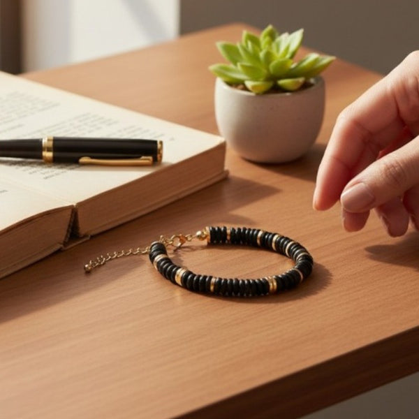 Gros plan des perles plates 6 mm en onyx noir du bracelet DISQUE®, d'un noir profond et brillant