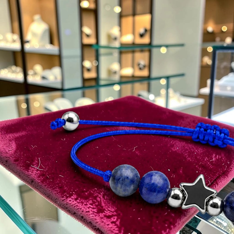 Gros plan du bracelet sodalite ÉTOILE®, breloque étoile en acier argenté entre les perles bleu roi