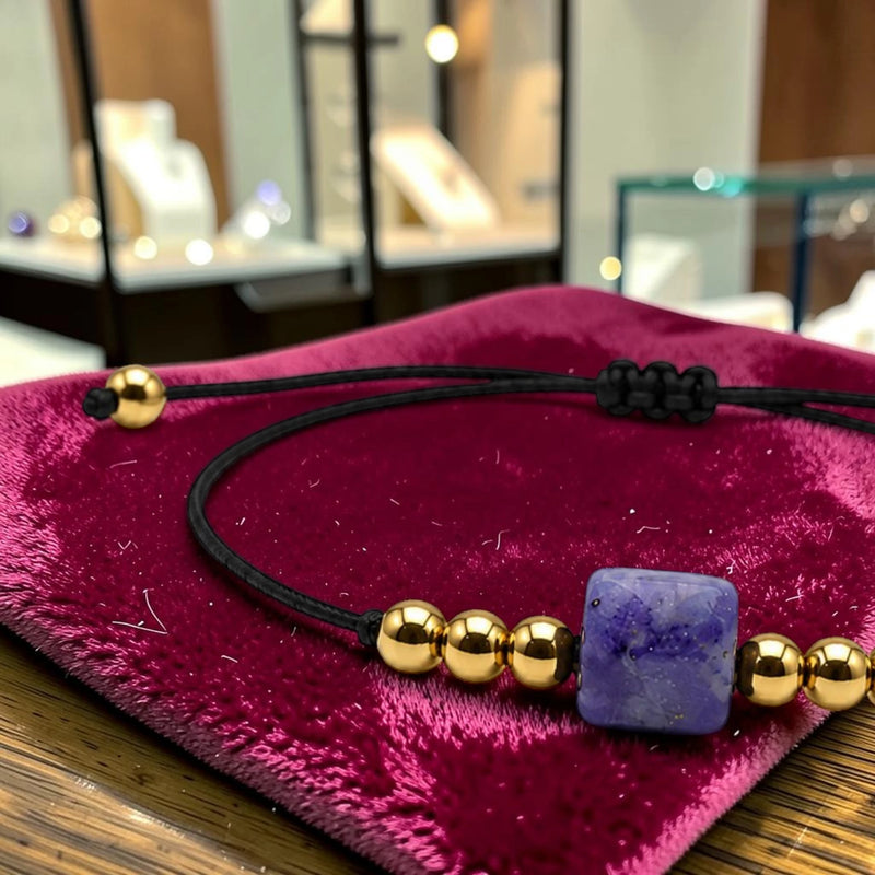 Gros plan de la pierre cube 8 mm en sodalite du bracelet cordon doré CUBE®, bleu roi veiné de blanc