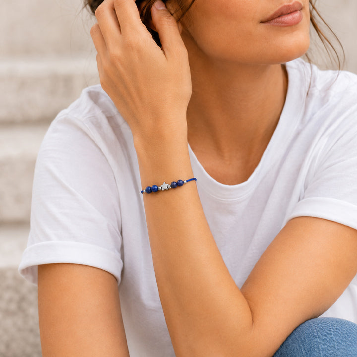 Bracelet pierre naturelle sodalite porté au poignet d'une femme, cordon bleu et étoile argentée ÉTOILE®
