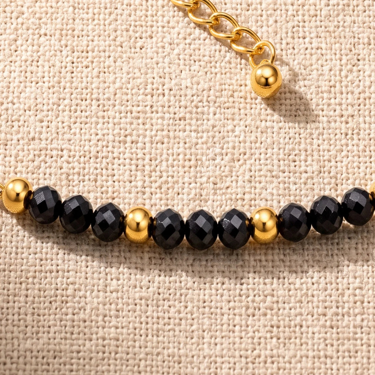 Gros plan sur les perles facettées de spinelle noir de 3 mm du bracelet FILÉA®