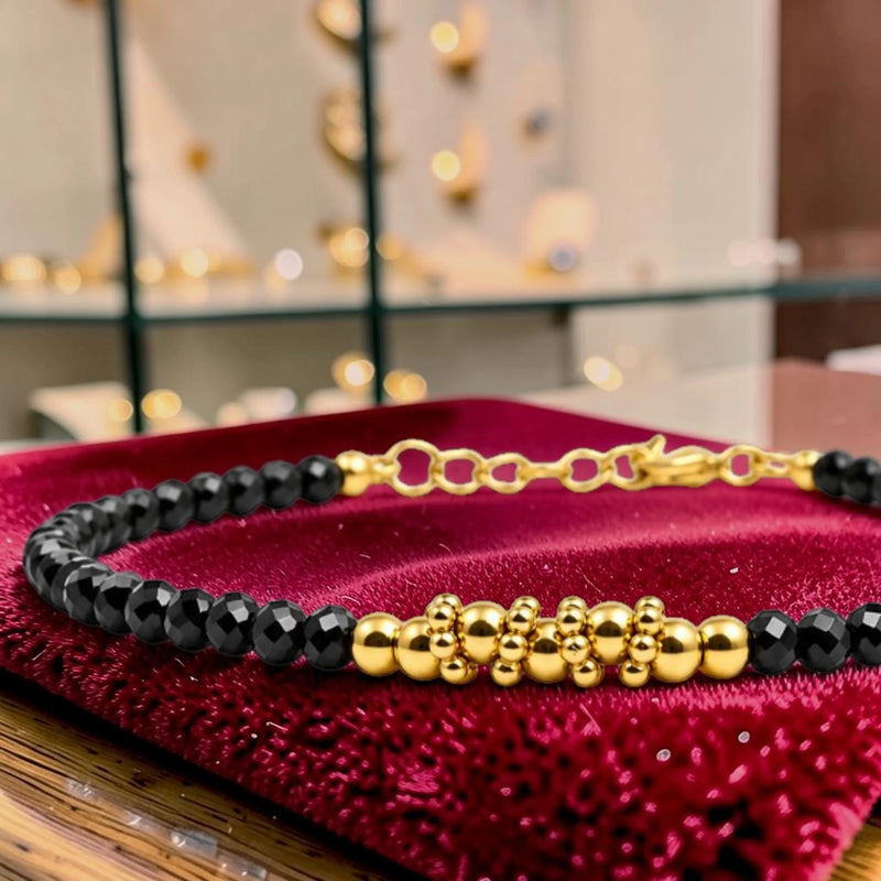Détail des perles facettées en spinelle noir et du motif de perles en acier doré, bracelet FINA®