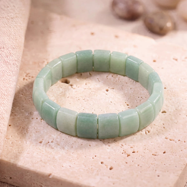 Bracelet aventurine plate en plaques de 14 mm, pierre verte pailletée posée sur une dalle de travertin