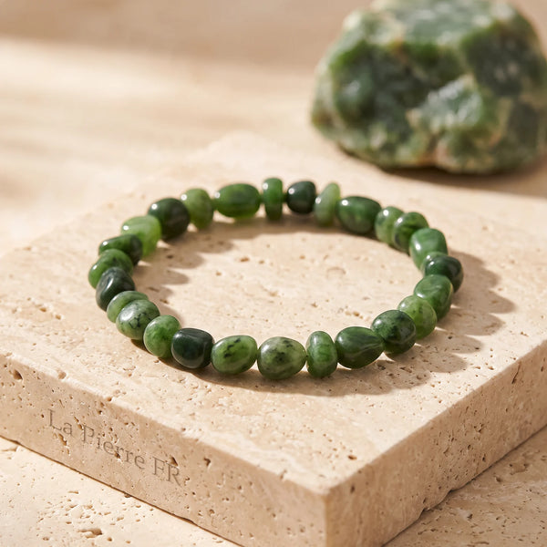Bracelet jade véritable en pierres roulées vertes sur un bloc de travertin
