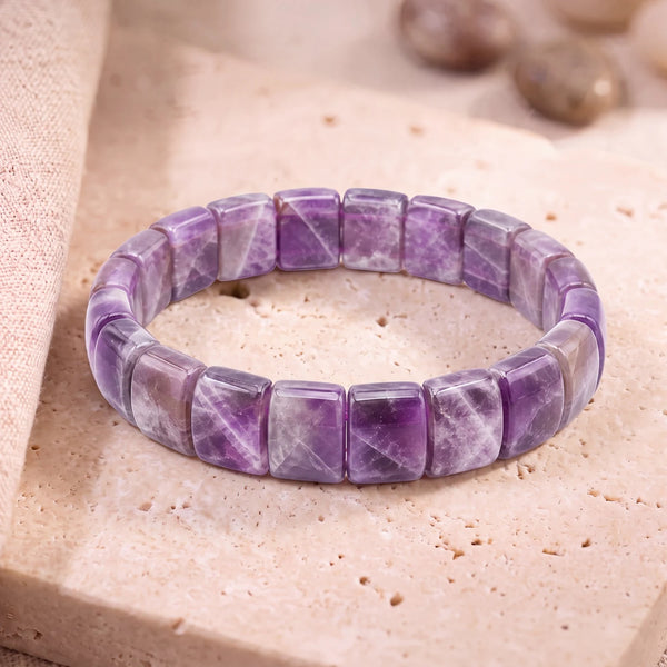 Bracelet améthyste chevron homme en plaques de 14 mm à bandes violettes et blanches, sur dalle de travertin
