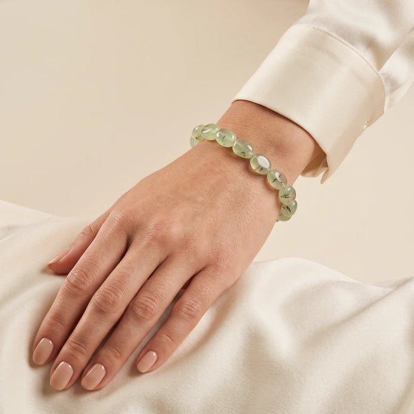 Bracelet préhnite porté au poignet d'une femme, bijou naturel en pierres roulées vertes