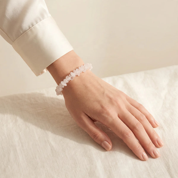 Bracelet chips en quartz rose porté par une femme, bijou rose pâle en pierre naturelle