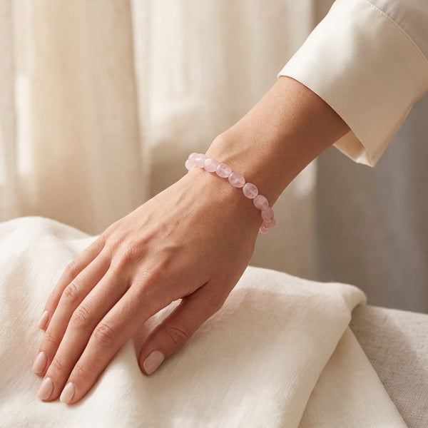 Bracelet quartz rose femme porté au poignet, pierres roulées douces sur fil élastique