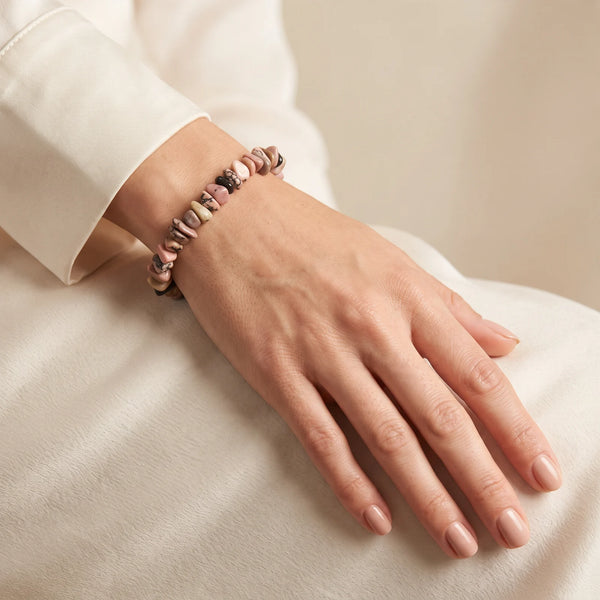 Bracelet rhodonite baroque porté au poignet d'une femme, pierre rose et noire