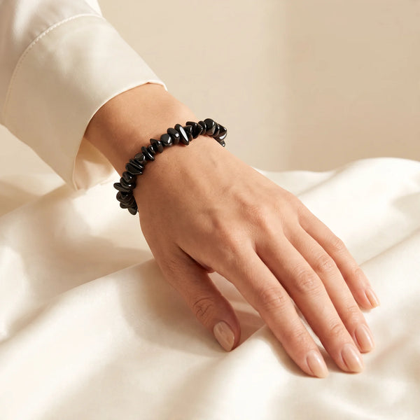 Bracelet tourmaline noire porté au poignet d'une femme, pépites baroques sur élastique