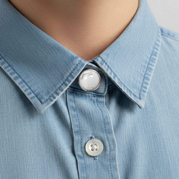 Cache bouton en howlite blanche clipsé au col d'une chemise en jean