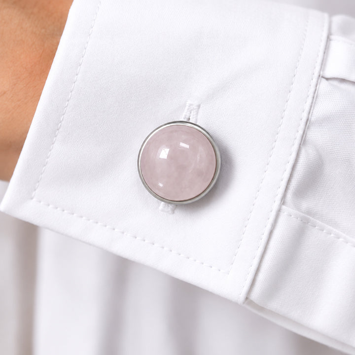 Cache bouton chemise femme en quartz rose clipsé sur le bouton du poignet d'une chemise blanche