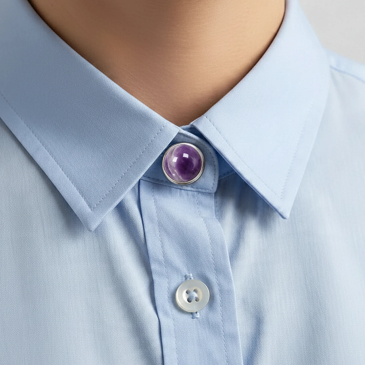 Cache bouton en améthyste violette clipsé sur le bouton du col d'une chemise