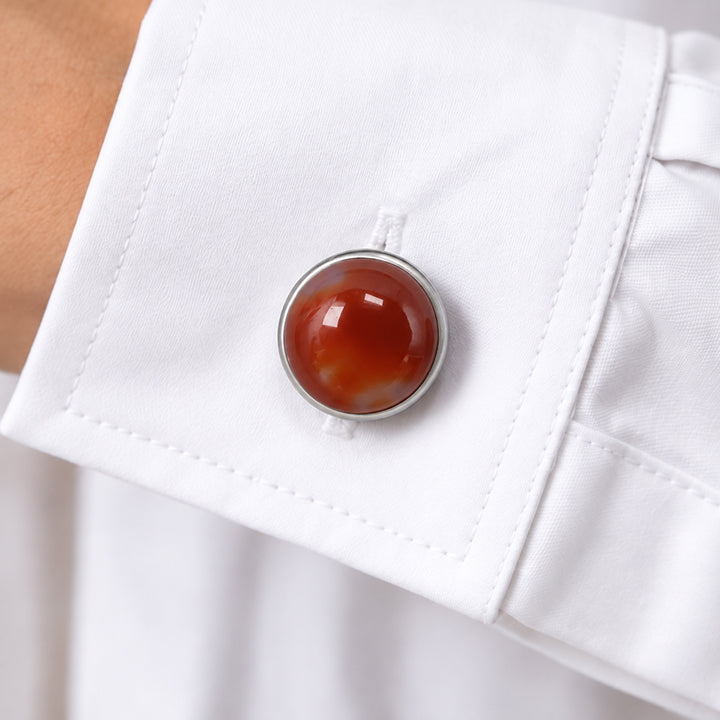 Cache bouton femme en cornaline clipsé sur le bouton du poignet d'une chemise blanche