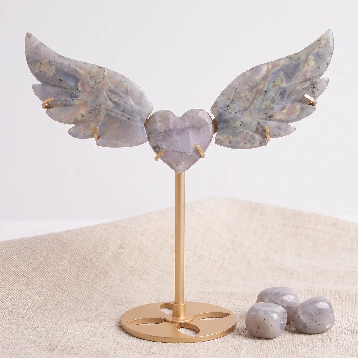 Cœur ailes d'ange en pierre labradorite sur un lin naturel avec trois pierres roulées