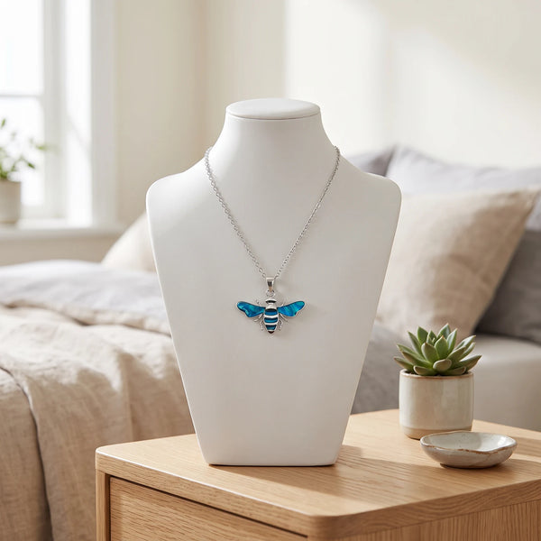 Collier abeille bleu en nacre naturelle porté sur un buste, pendentif abeille sur chaîne argentée
