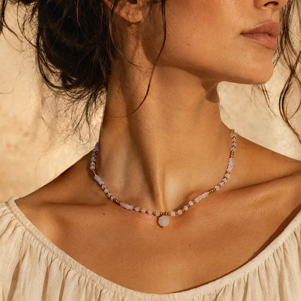 Collier acier inoxydable doré femme en quartz rose porté par une femme, chaîne et perles dorées