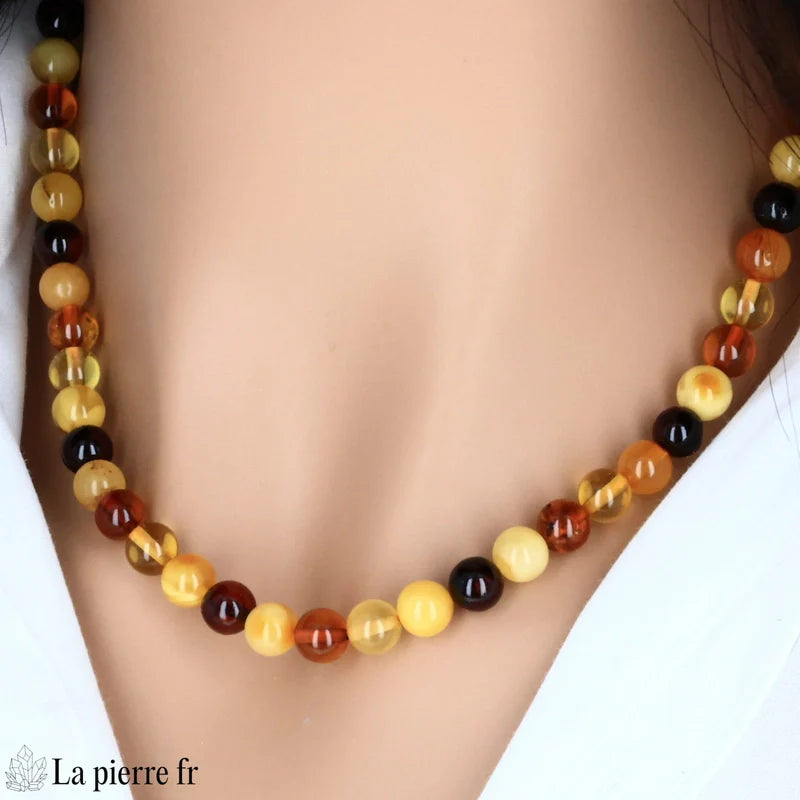 Collier de perles rondes en Ambre multicolore porté, montrant son style classique et ses teintes chaleureuses.