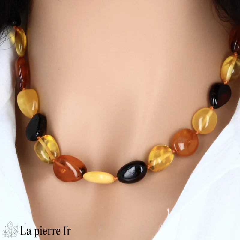 Collier en Ambre forme olives porté, mettant en valeur son design sculptural et sa couleur chaude.