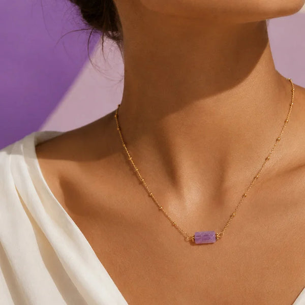 Collier améthyste femme LUMIA® porté par une femme, tube en améthyste sur chaîne dorée