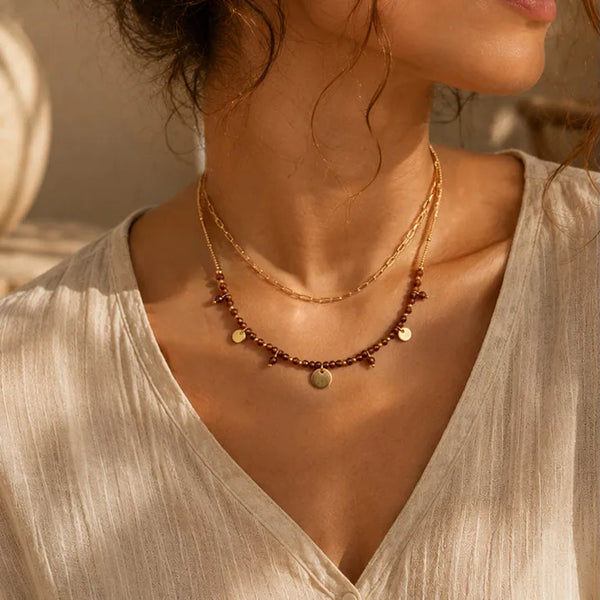 Collier bohème en œil de tigre porté par une femme, chaîne et perles dorées