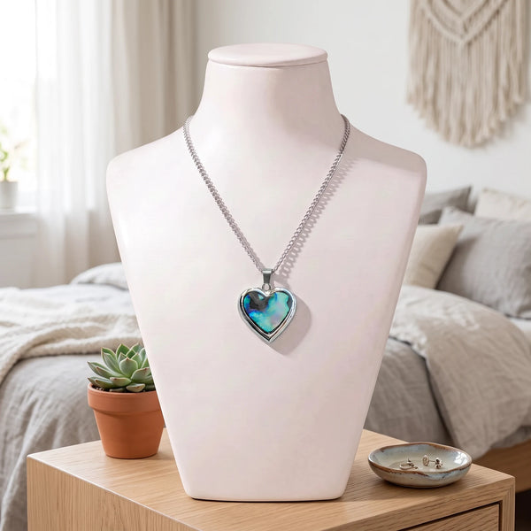 Collier cœur bleu en nacre naturelle porté sur un buste, pendentif cœur sur chaîne argentée
